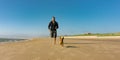 Man with his little cute dog running at the beach Royalty Free Stock Photo