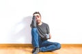 Man on his 40s sitting on the floor of empty apartment with gesture of tiredness or depression Royalty Free Stock Photo