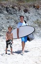 Man and his son arriving at the beach to surf Royalty Free Stock Photo