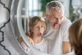Man and his son making funny faces near the mirror Royalty Free Stock Photo