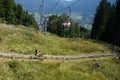 Man with Little Boy Ride the Luge Down an Alpine hill in Oberammergau, Germany