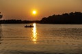 Man and his wife fishing in an aluminum boat at sunset