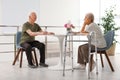 Man and his wife with walking frame sitting at table Royalty Free Stock Photo