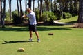 A man hits a golf ball near the hole on the green of a private golf club. Active summer luxury vacation Royalty Free Stock Photo