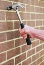 Man hitting a brick wall with a hammer Royalty Free Stock Photo