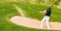 Man hitting golf ball out of a bunker Royalty Free Stock Photo