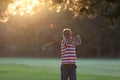 Man hitting iron club in the golf course club in the sunset Royalty Free Stock Photo