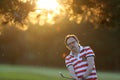 Man hitting iron club in the golf course club in the sunset Royalty Free Stock Photo