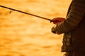 Man hobby fishing on sea tightens a fishing line reel of fish. Calm surface sea. Close-up of a fisherman hands twist Royalty Free Stock Photo