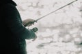 Man hobby fishing on sea tightens a fishing line reel of fish. Calm surface sea. Close-up of a fisherman hands twist Royalty Free Stock Photo