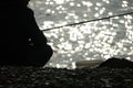 Man hobby fishing on sea tightens a fishing line reel of fish. Calm surface sea. Close-up of a fisherman hands twist Royalty Free Stock Photo