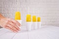 Man hoilding corn in cup with stick on white bricks wall background