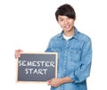 Man hold with blackboard showing phrase of semester start