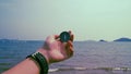 Man hold compass with sea and mountain at the background. Royalty Free Stock Photo