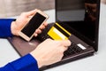 Man hold credit card in hand and entering security code using laptop keyboard at home Royalty Free Stock Photo