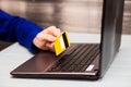 Man hold credit card in hand and entering security code using laptop keyboard at home Royalty Free Stock Photo