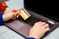 Man hold credit card in hand and entering security code using laptop keyboard at home Royalty Free Stock Photo
