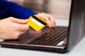 Man hold credit card in hand and entering security code using laptop keyboard at home Royalty Free Stock Photo