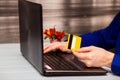 Man hold credit card in hand and entering security code using laptop keyboard at home Royalty Free Stock Photo