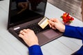 Man hold credit card in hand and entering security code using laptop keyboard at home Royalty Free Stock Photo