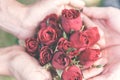 Man hold a fresh red roses offer to the women, girlfriend for a gift of valentins flower surprise. Man submit the red roses flower