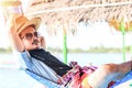 A man hold hat and sleep on hammock near the river. Royalty Free Stock Photo