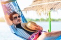 A man hold hat and sleep on hammock near the river. Royalty Free Stock Photo