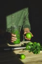 Man hold healthy detox smoothie, cooking with blender with fresh fruits and greens spinach,