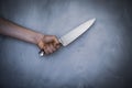 Man hold knife - aggression. Big kitchen knife in man hand. Large kitchen knife in a man`s hand, on a gray background