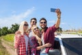 Man hold smart phone camera taking selfie photo friends smile countryside car Royalty Free Stock Photo