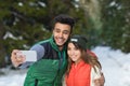 Man Hold Smart Phone Camera Taking Selfie Photo Snow Forest Young Mix Race Couple Outdoor Winter Royalty Free Stock Photo