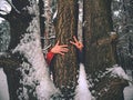 Man hold tree trunk with the frozen bark covered with sticky snow