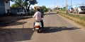 man holded snake during bike ride on road in India Oct 2019 Royalty Free Stock Photo