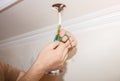 Man is holding adhesive tape in his hands. Electrical insulator for light bulb. Maintenance repair works in the flat. Restoration