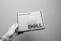 Man holding against gray background a cardboard with DELL logo