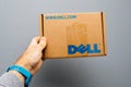 Man holding against gray background a cardboard with DELL logo