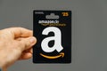 Man holding against gray background 25 Euros Amazon gift card is