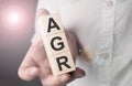 Man holding agr word on wooden cube