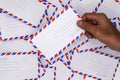 A man holding airmail envelopes  on white office desk. Royalty Free Stock Photo