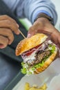 Man holding american hamburger with hands. Big delicious america Royalty Free Stock Photo