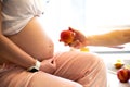 Man holding apple near pregnant woman. Healthy food during pregnancy. Vitamins and fruit Royalty Free Stock Photo