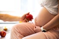 Man holding apple near pregnant woman. Healthy food during pregnancy. Vitamins and fruit Royalty Free Stock Photo