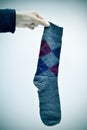 Man holding an argyle patterned sock, vignetted