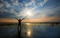 Man holding arms up in praise in sunset while being in water Royalty Free Stock Photo