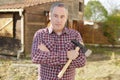 Man holding axe for chopping firewood in yard Royalty Free Stock Photo