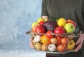 Man holding basket full of fresh  vegetables and fruits against color background, closeup Royalty Free Stock Photo