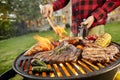 Man holding a beer grilling meat on a BBQ Royalty Free Stock Photo