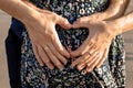 Man and woman holding heart shaped hands on her pregnant belly Royalty Free Stock Photo