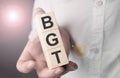 Man holding bgt word on wooden cube Royalty Free Stock Photo