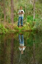 Man holding Bible while his reflection in the water shows him holding a sword representing power of faith Royalty Free Stock Photo